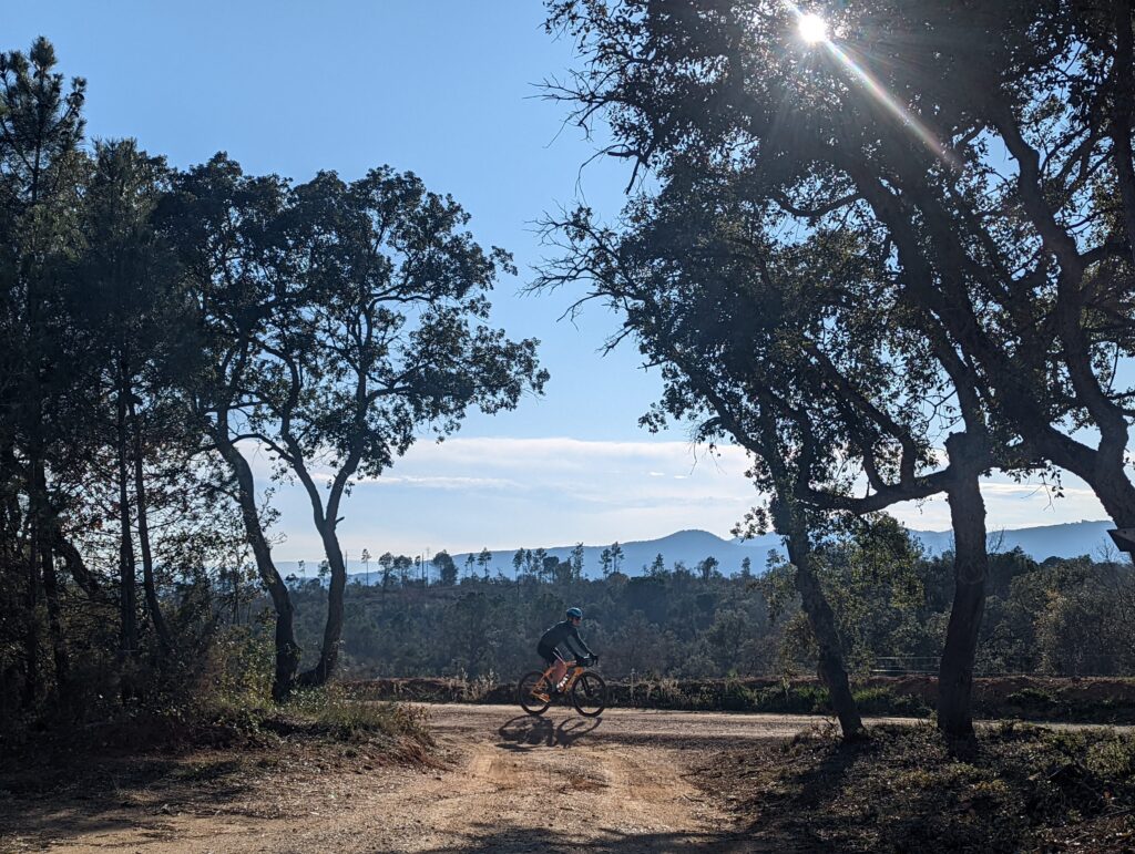 A gravel cyclist riding along the side of a mountain in Spain to showcase the gravel riding views to be found in Girona.